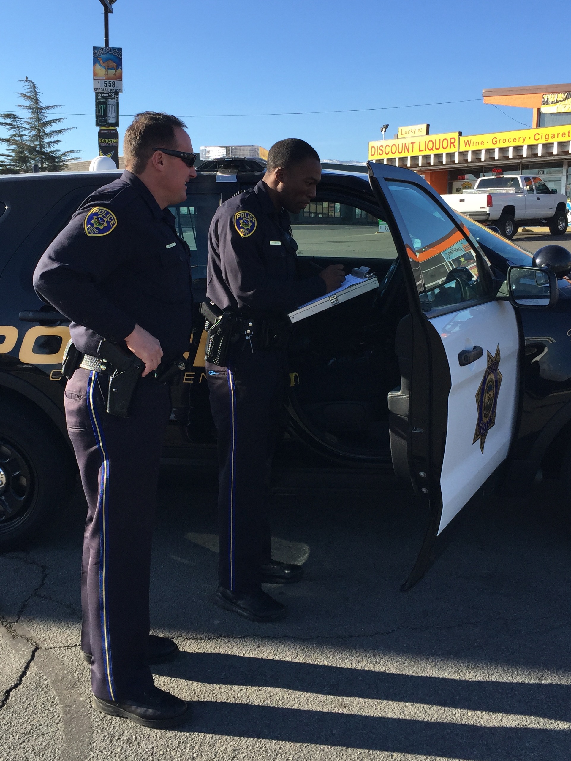 Officers standing outside squad car